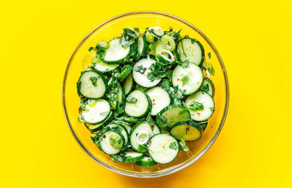 A glass bowl filled with freshly tossed Thai cucumber salad