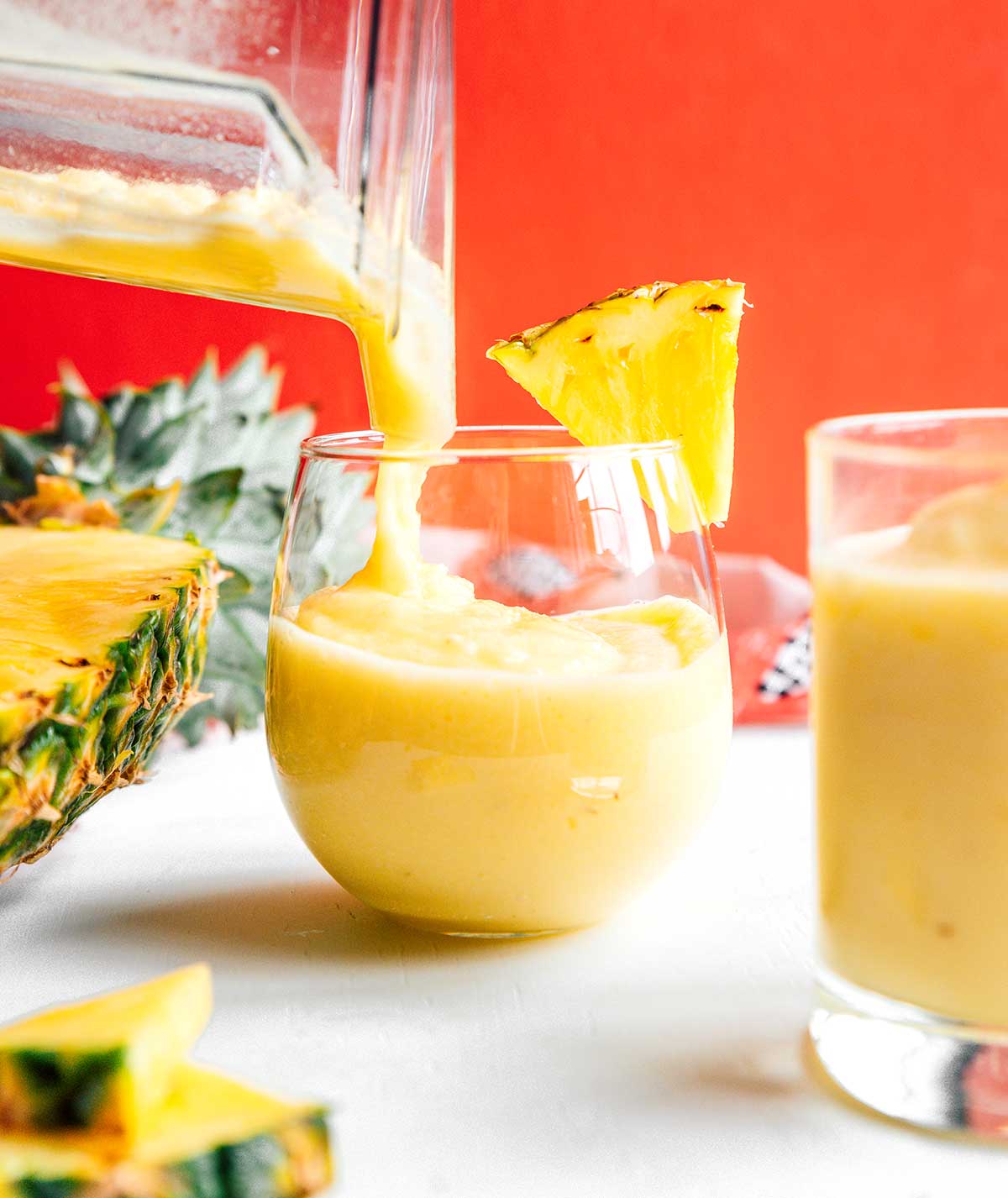 Pouring pineapple smoothie into a glass
