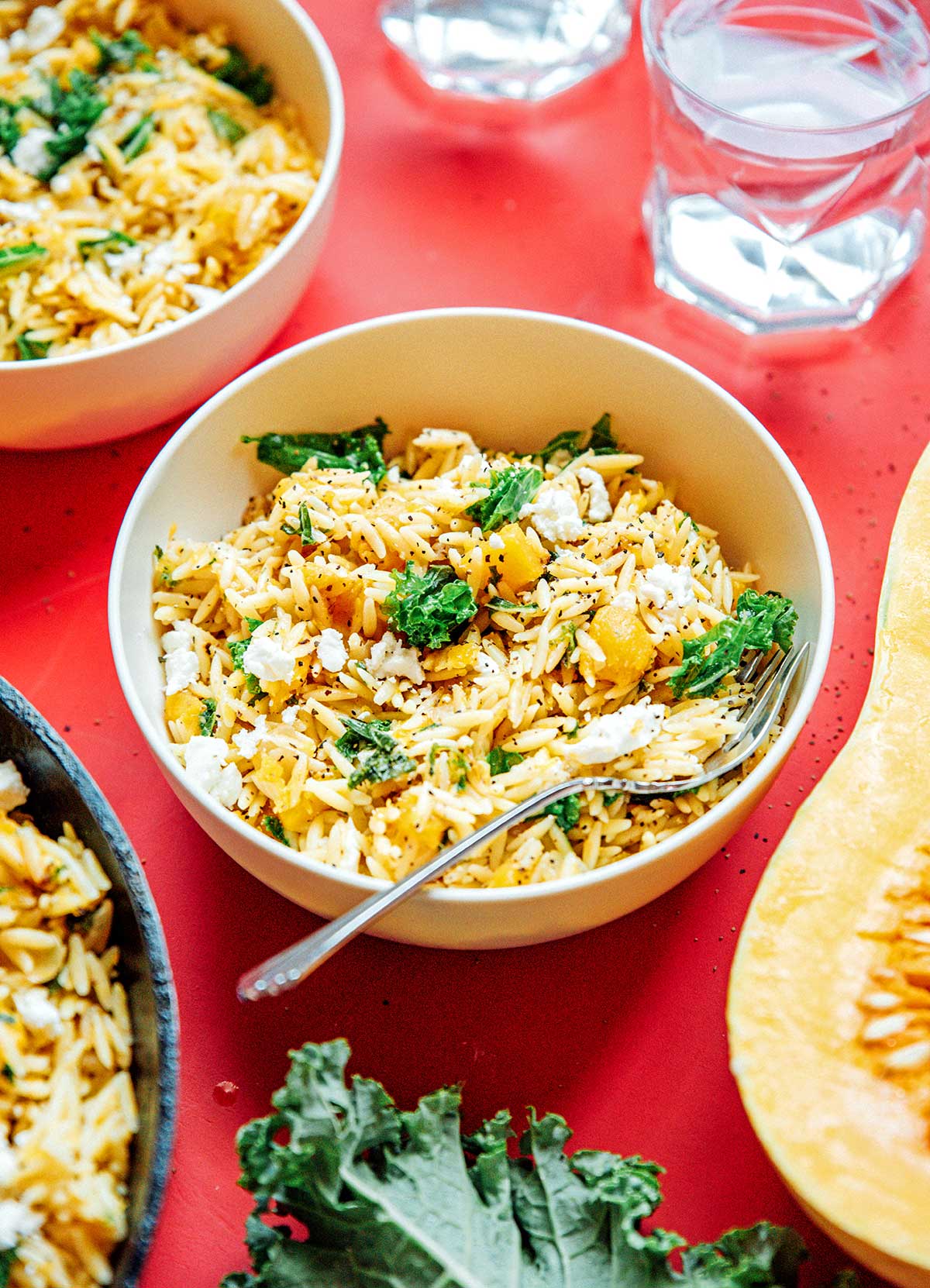 A white bowl filled with butternut squash orzo salad