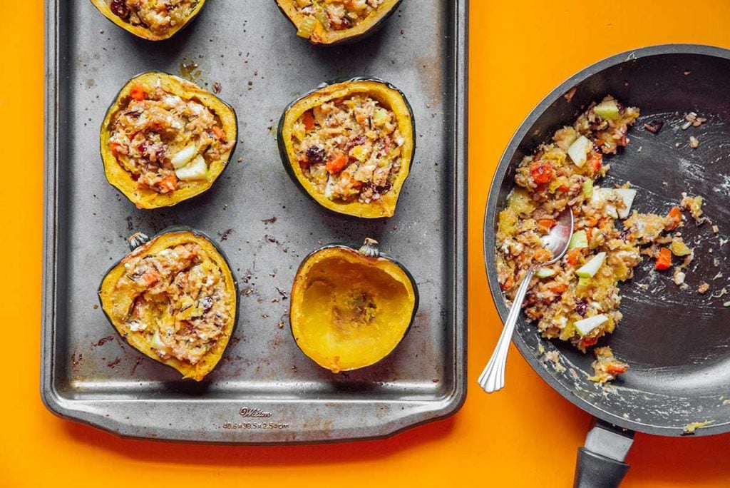 Filling cooked acorn squash halves with the stuffed acorn squash filling