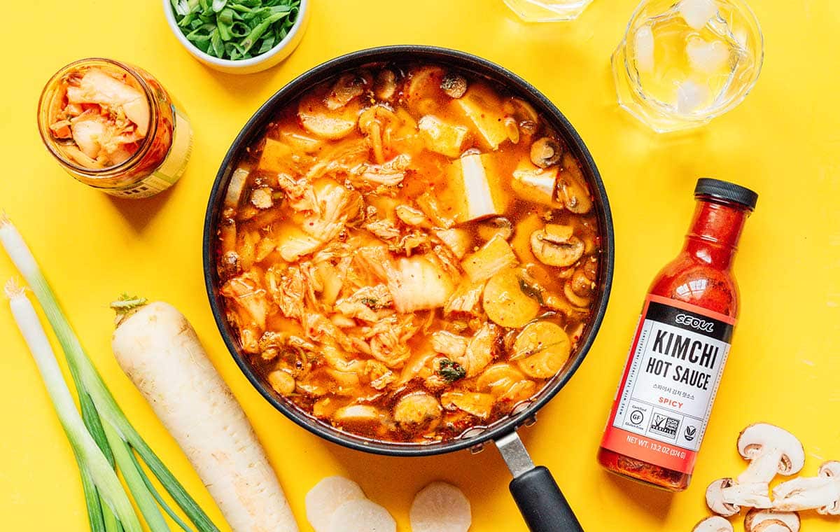 Kimchi soup in a pan on a yellow background