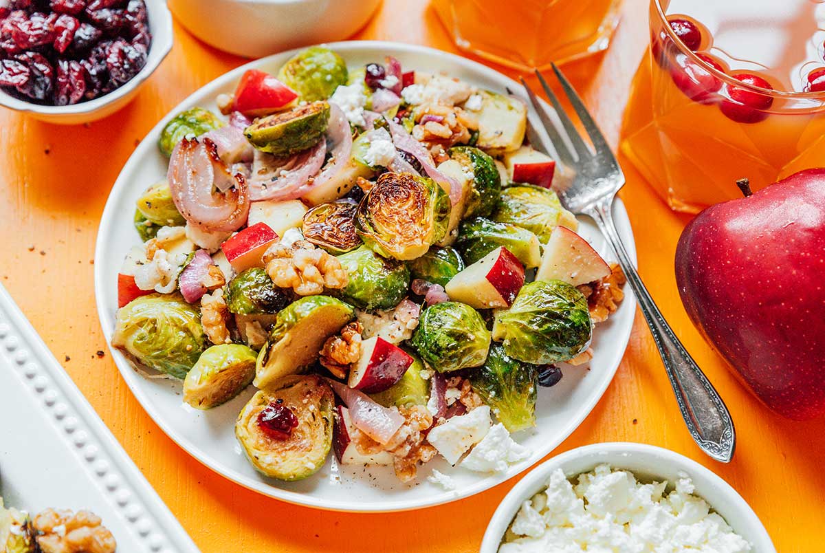 A white plate filled with roasted Brussels sprout salad