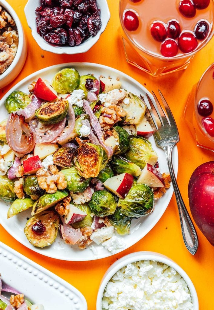 A white plate filled with roasted Brussels sprout salad