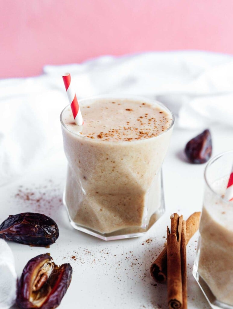 A glass filled with a healthy date shake and topped with cinnamon powder