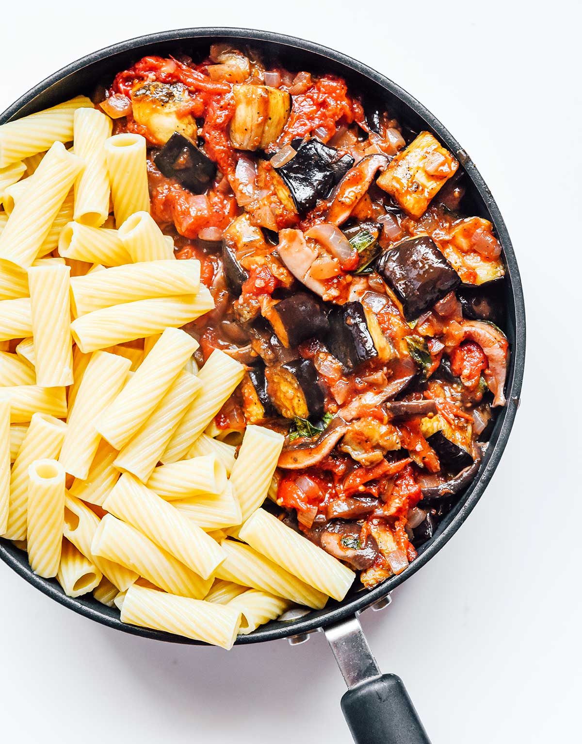 A skillet filled with vegetable bolognese sauce and rigatoni noodles