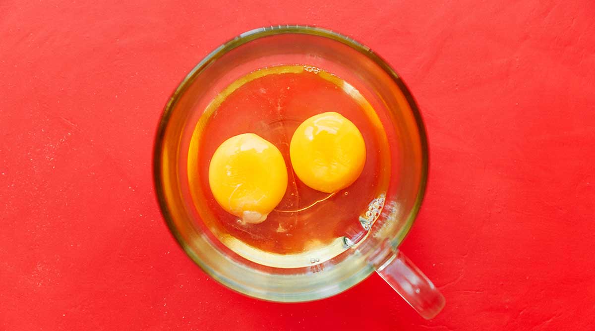 Two eggs in a clear glass mug
