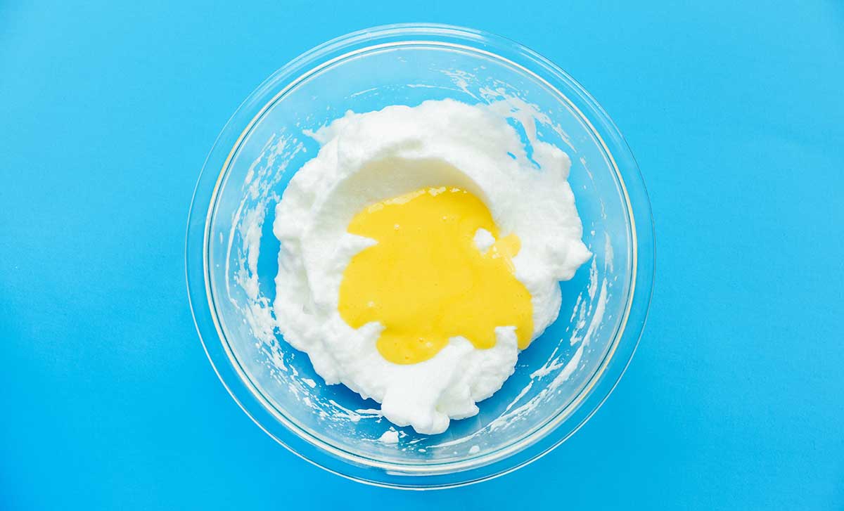 A clear bowl filled with beaten egg whites and yolks