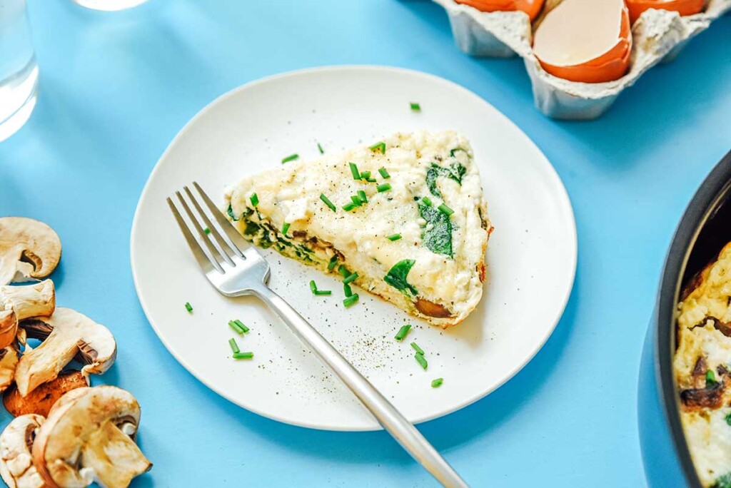 A white plate filled with a slice of egg white frittata 