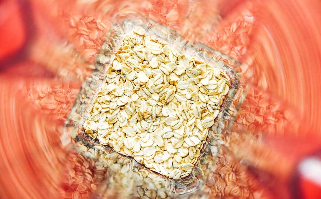 A food processor filled with whole rolled oats