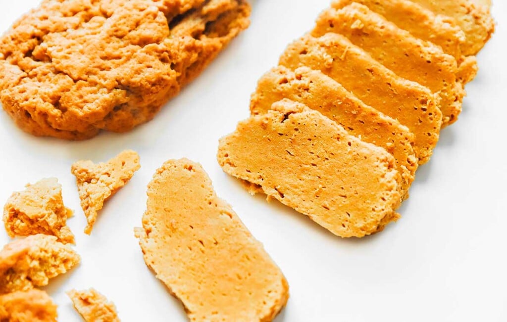 Seitan displayed in a pre-cut roll alongside thick cut slices to show its texture and consistency