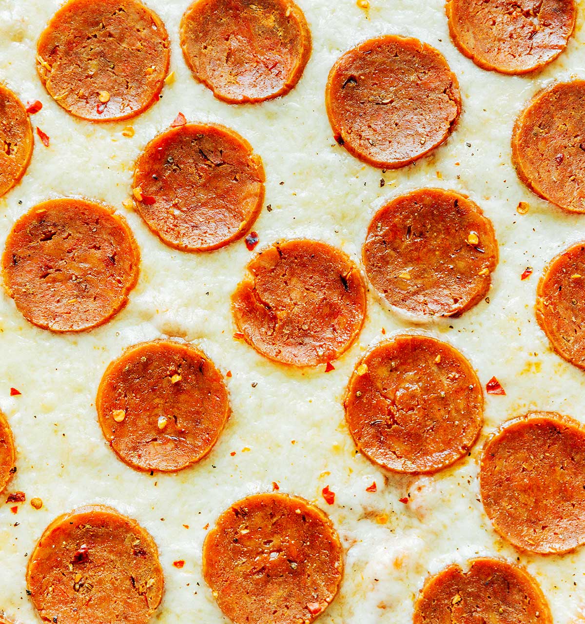 An up-close view of homemade pizza featuring cheese and vegetarian pepperoni
