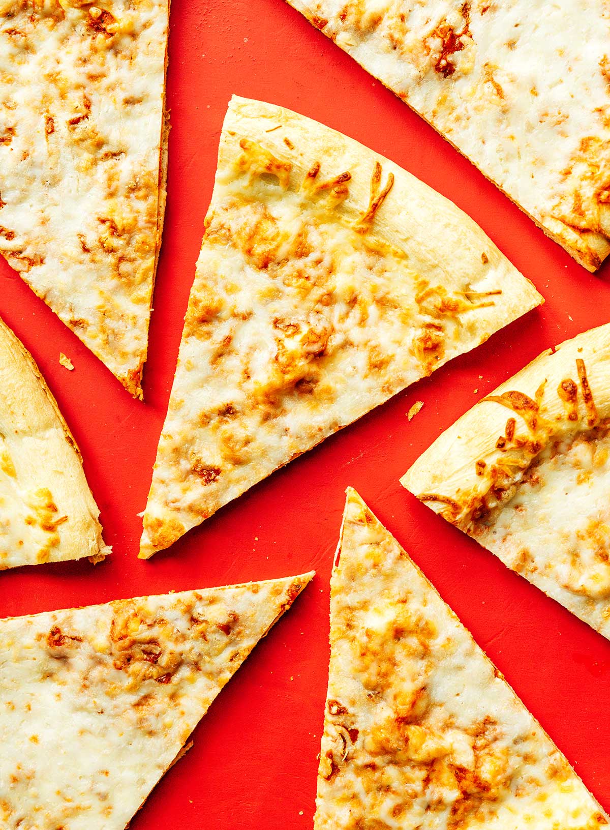 Leftover pizza slices neatly arranged on a red background