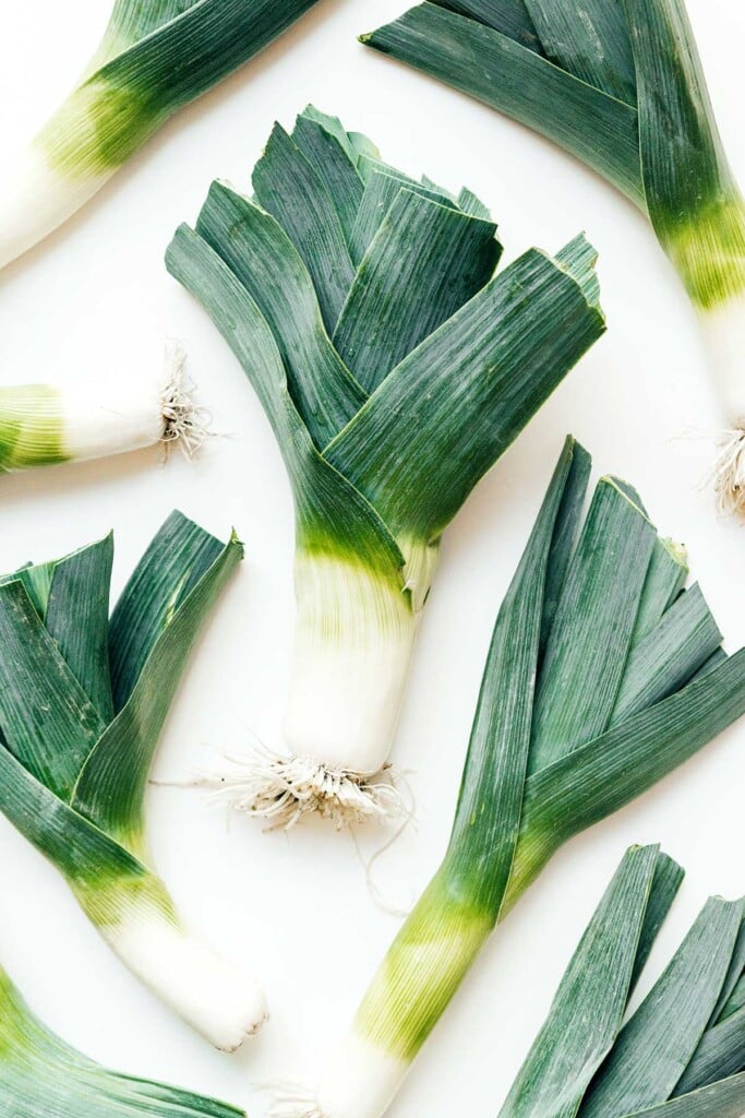 A bunch of leeks arranged neatly on a white background