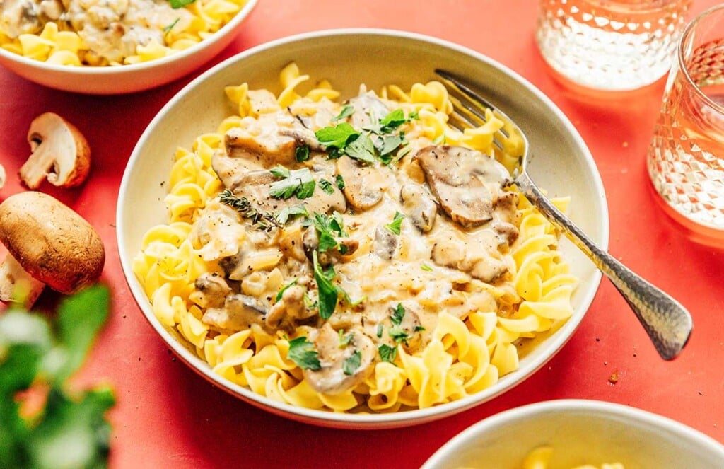 A white bowl filled with a large serving of vegetarian mushroom stroganoff