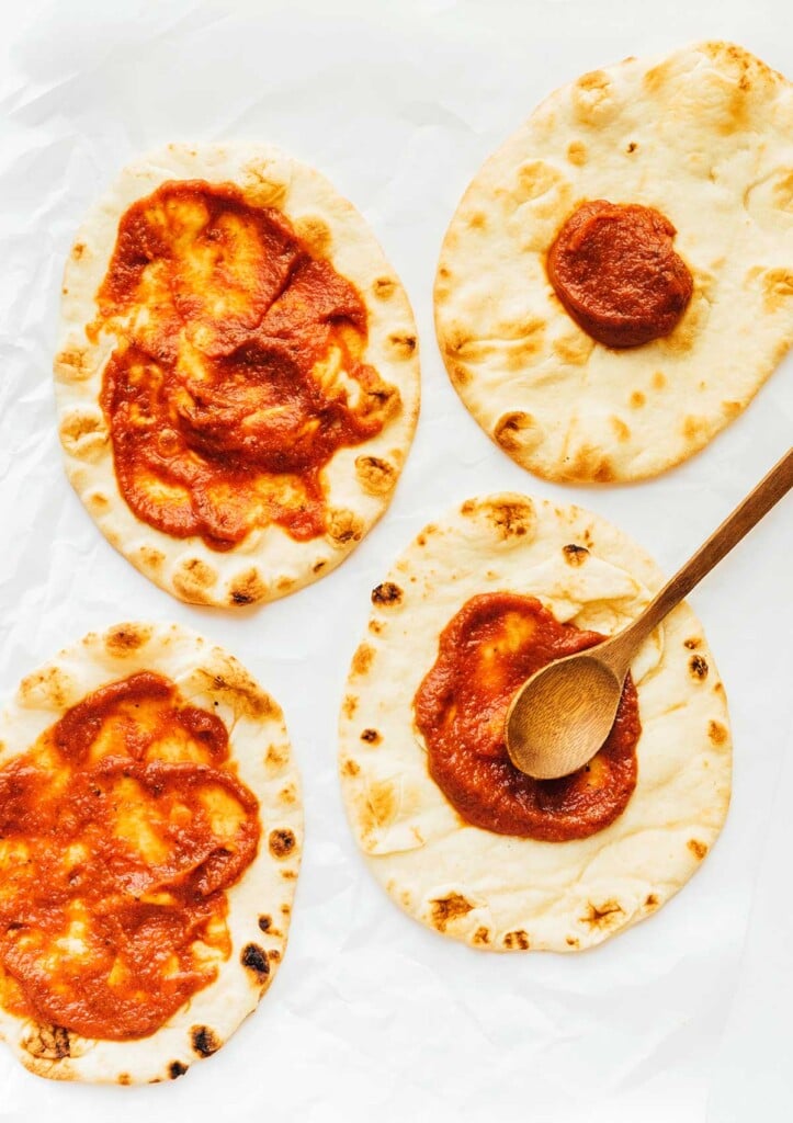 Four pieces of naan bread topped with sauce