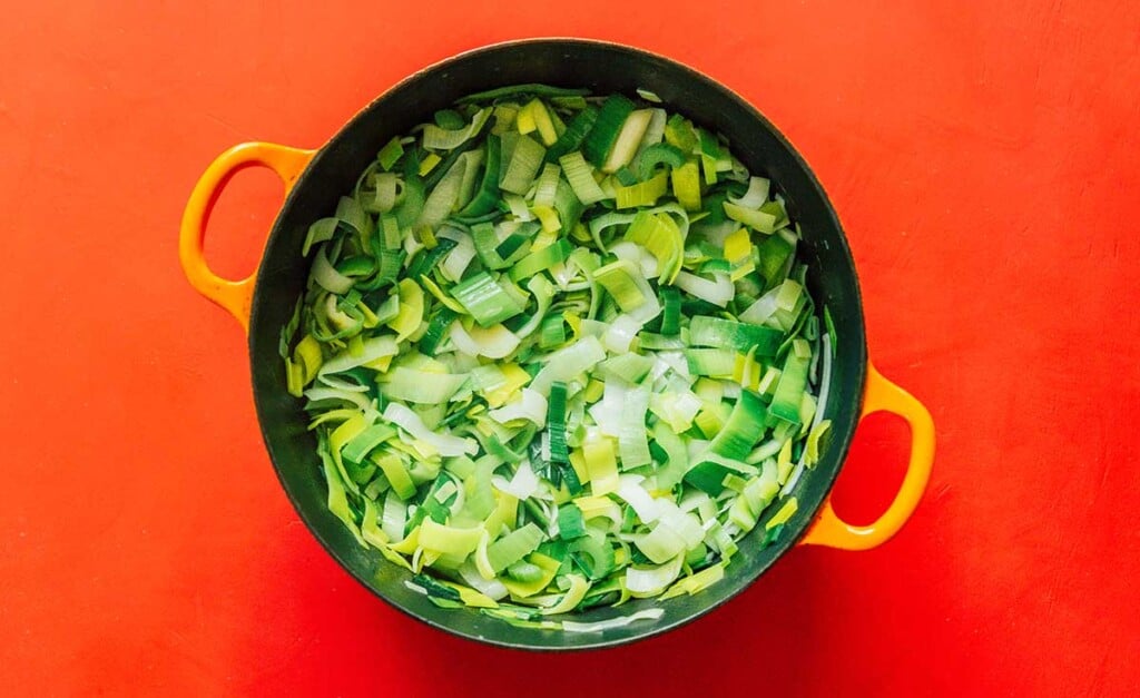 A large cooking pot filled with cleaned leek slices