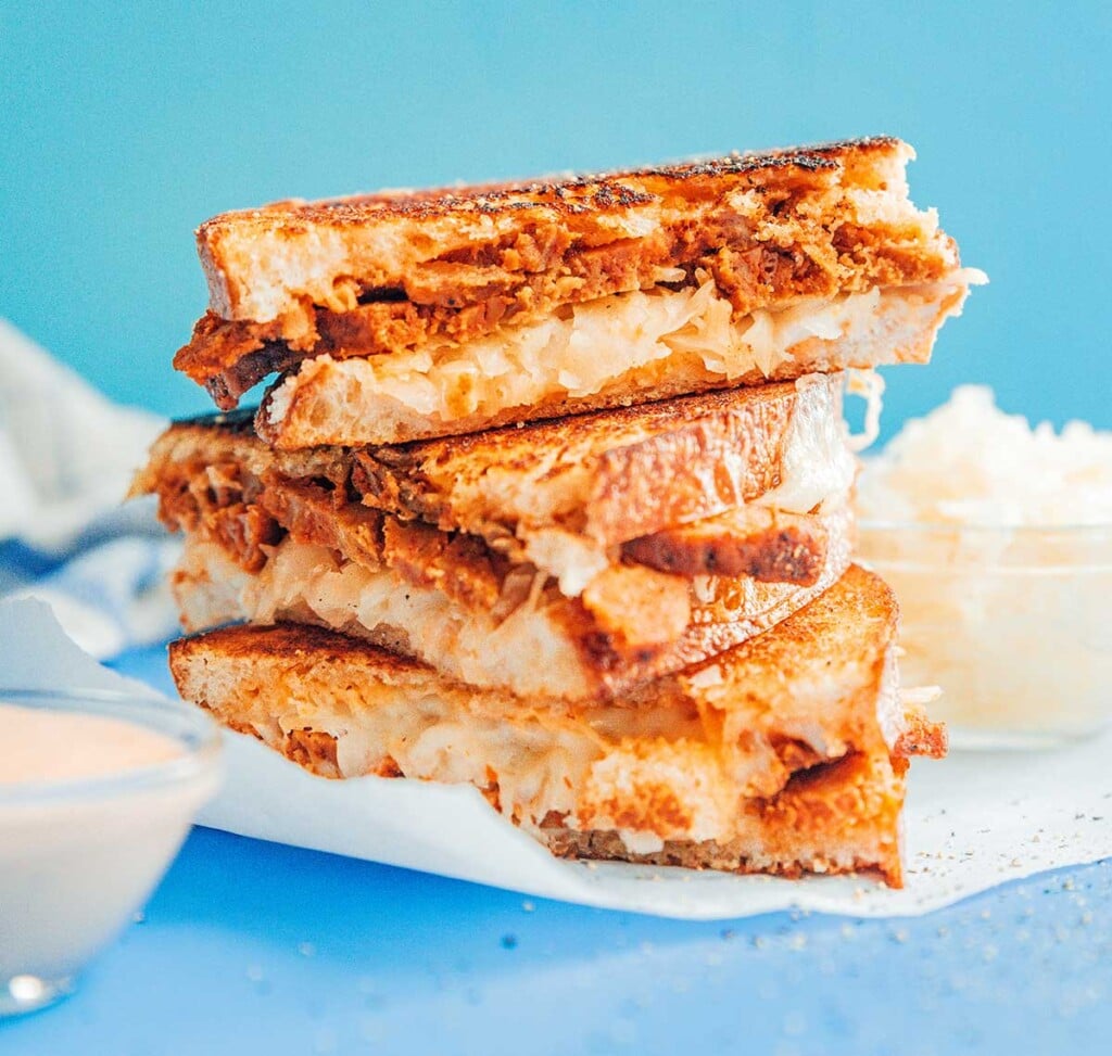 Three halves of a seitan reuben sandwich stacked on top of one another