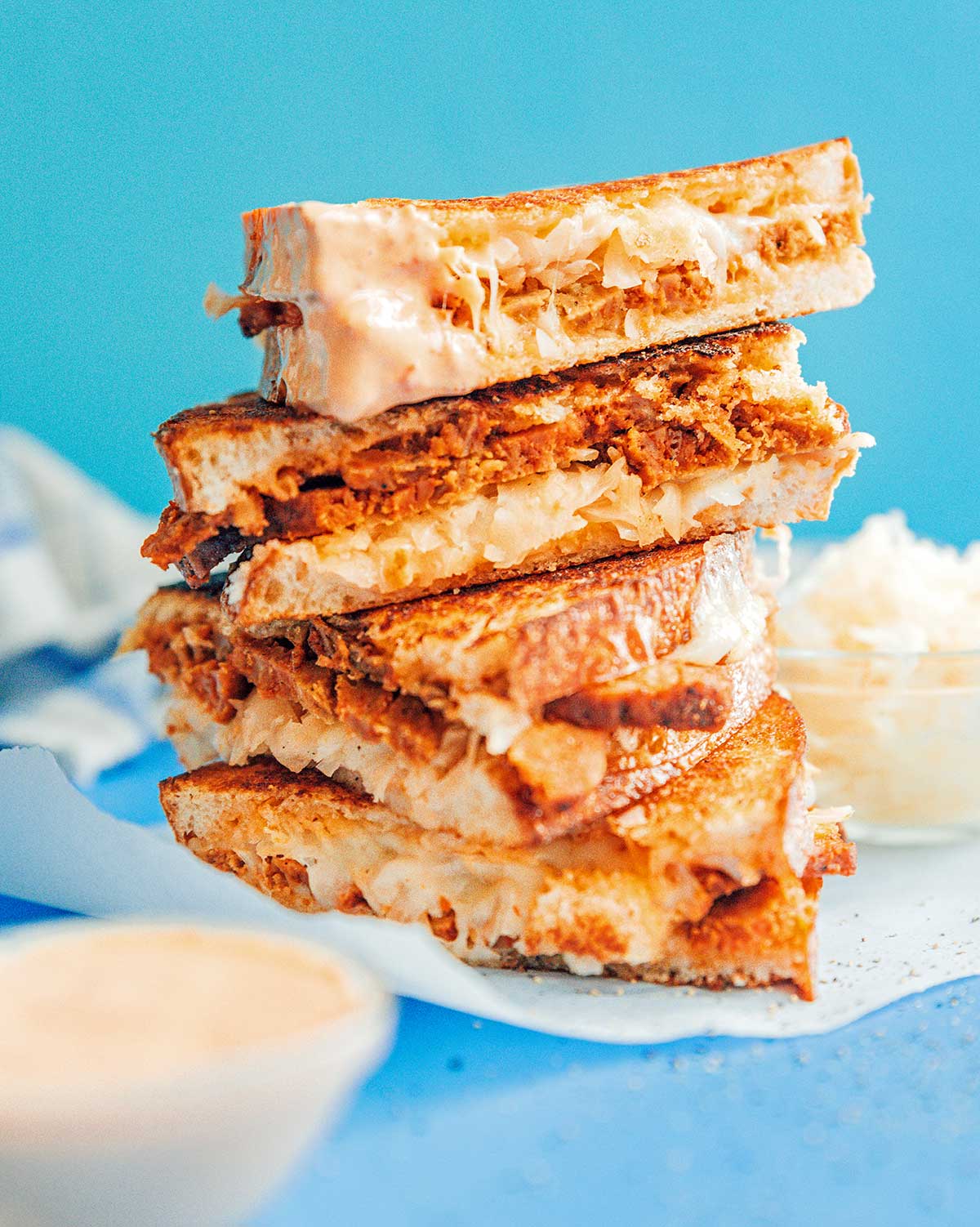 Four halves of a seitan reuben sandwich stacked on top of one another