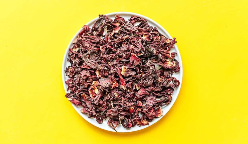 A white plate filled with dried hibiscus flower pieces
