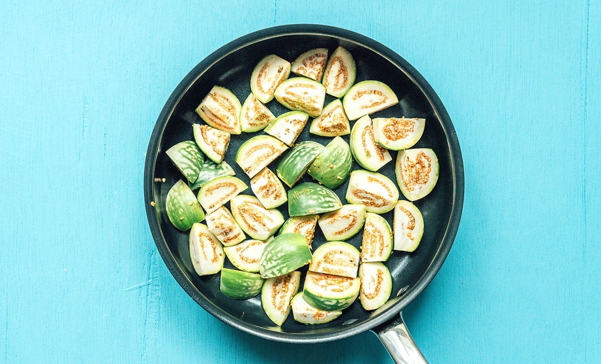 A skillet filled with chopped Thai green eggplant