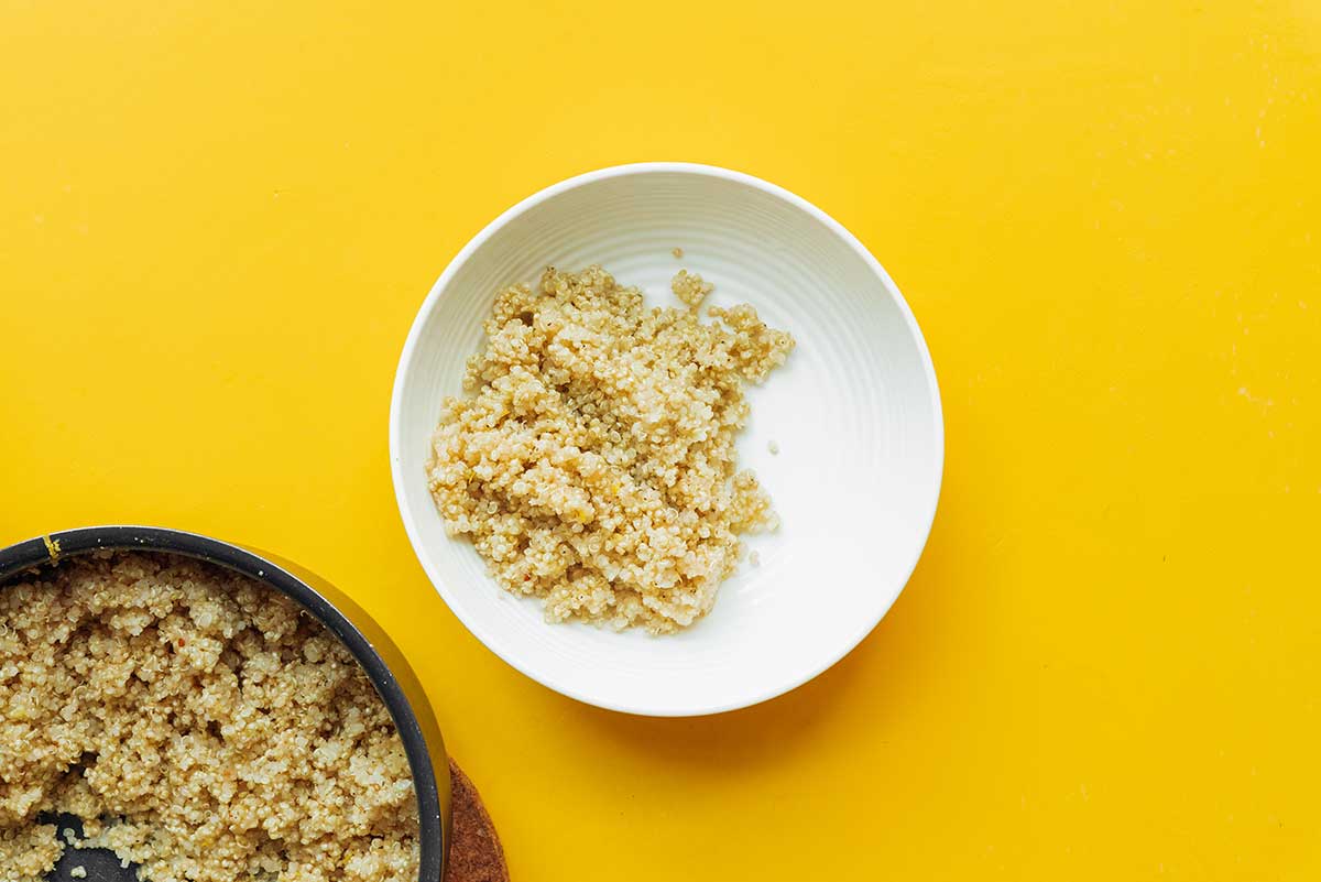 A white bowl filled with one serving of cooked quinoa