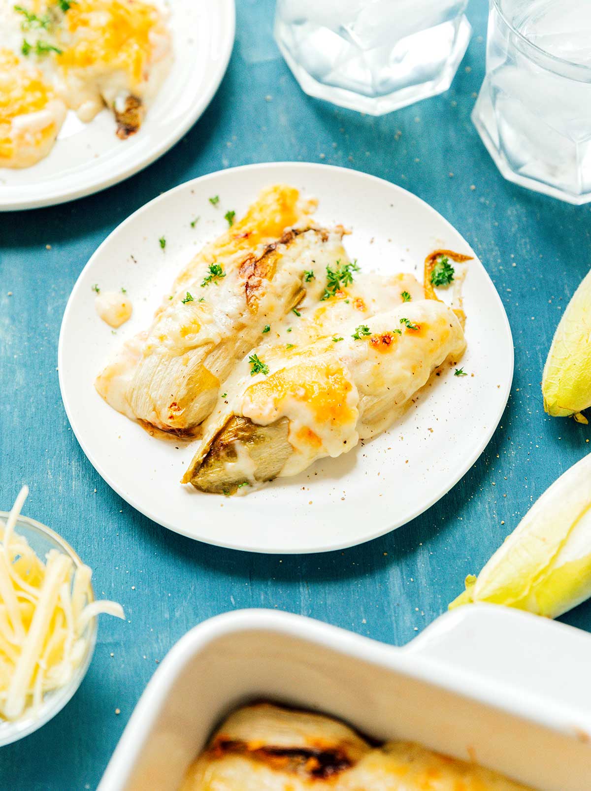 Two servings of Belgian endive gratin on a white plate