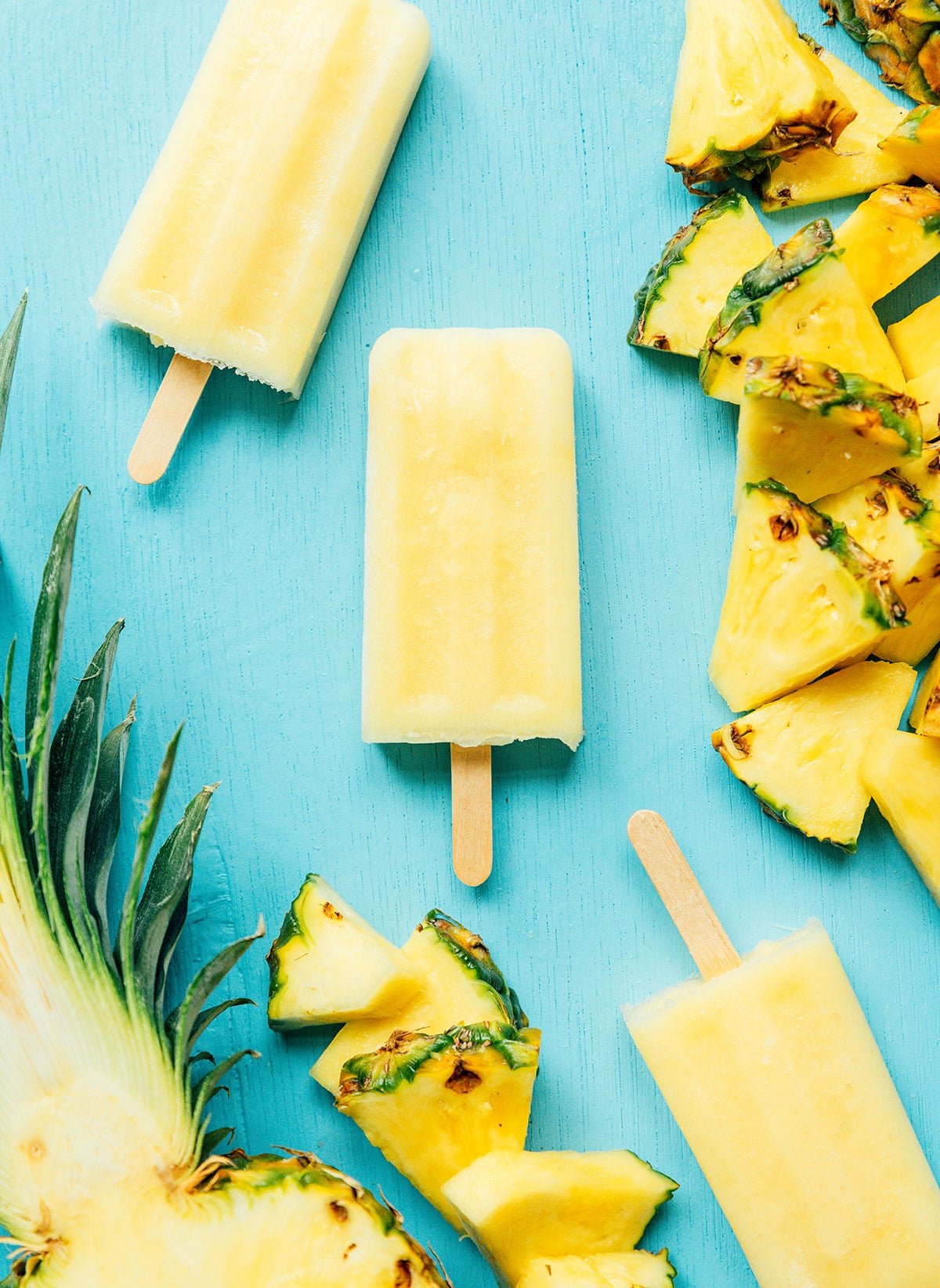 Yellow pineapple Mexican paletas on a blue background