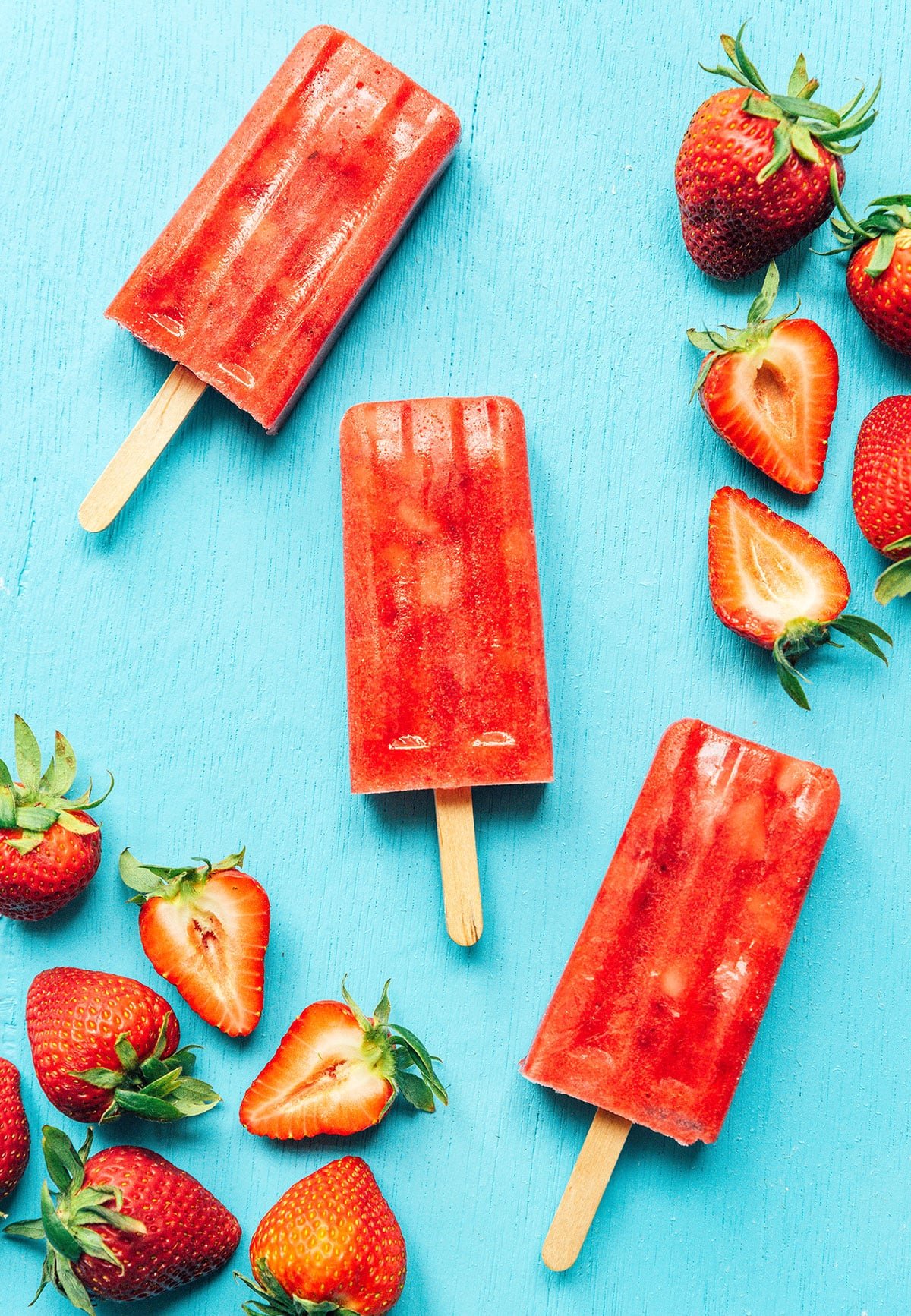 Red strawberry Mexican paletas on a blue background