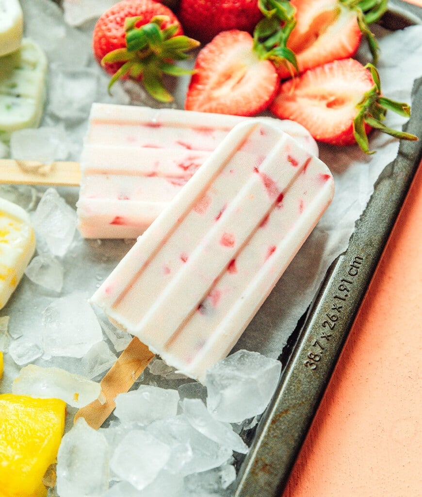 A close up shot detailing the texture and colors of strawberry and yogurt popsicles