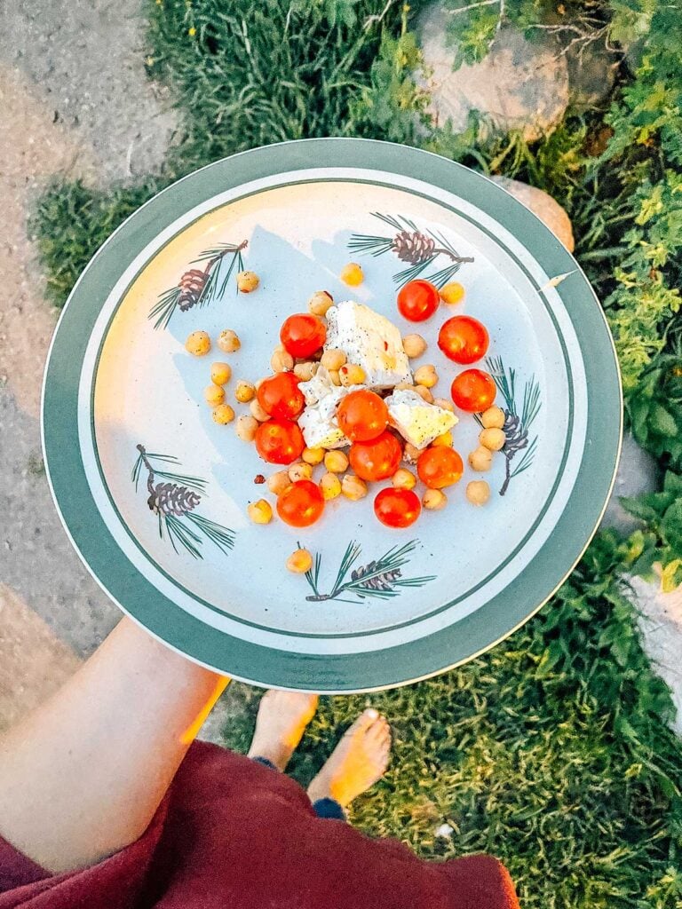 Holding a plate filled with a serving of campfire feta bake