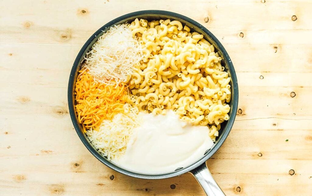 A skillet filled with campfire mac and cheese ingredients