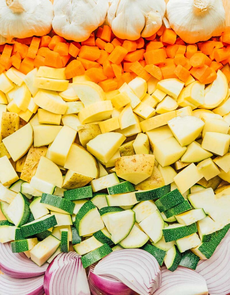 Uncooked and chopped veggies laid out in rainbow order 