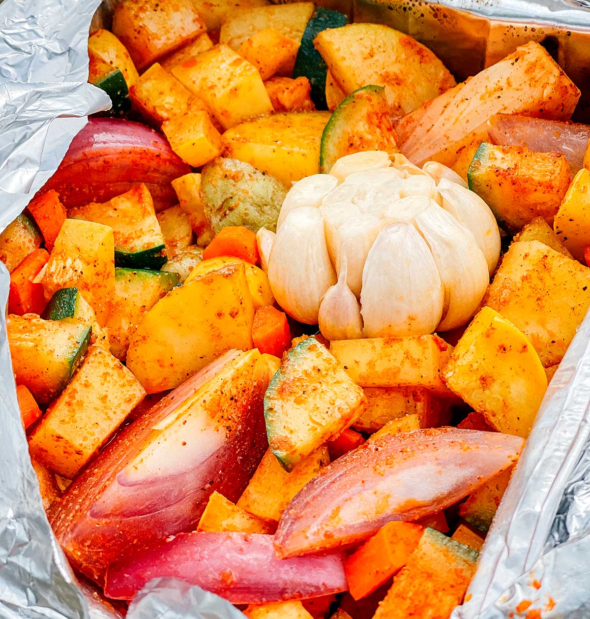 An up close look detailing the texture and seasonings of campfire roasted vegetables
