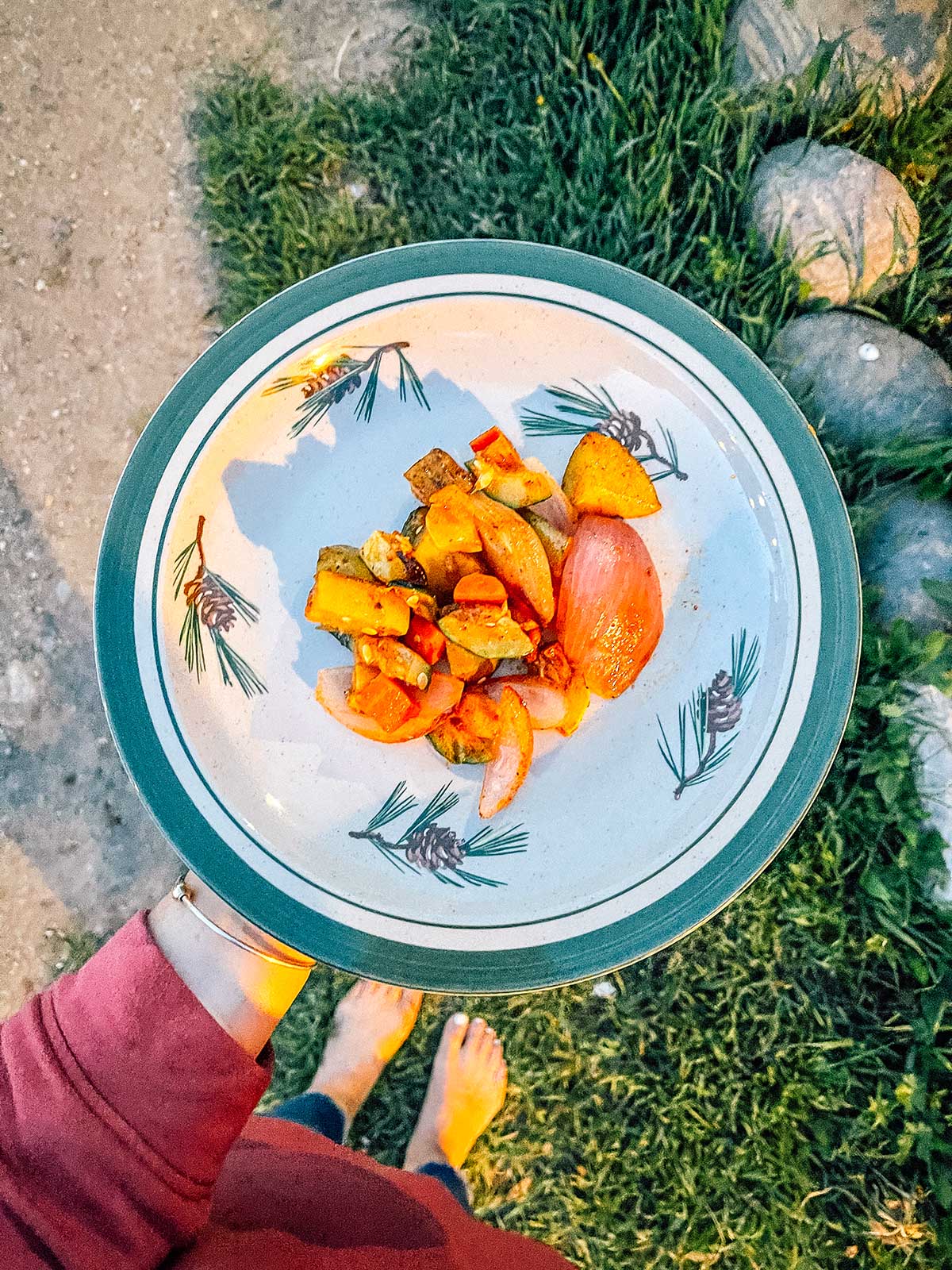 Holding a plate of campfire roasted veggies