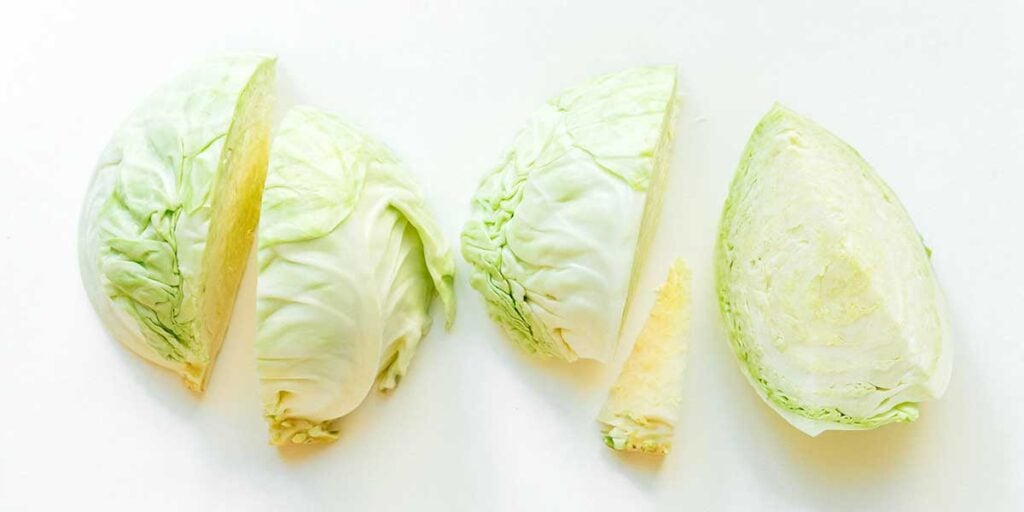 Four quarters of a head of cabbage lined up on a white background