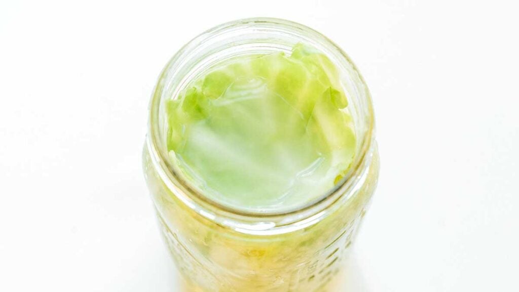 A glass jar filled with unfermented cabbage