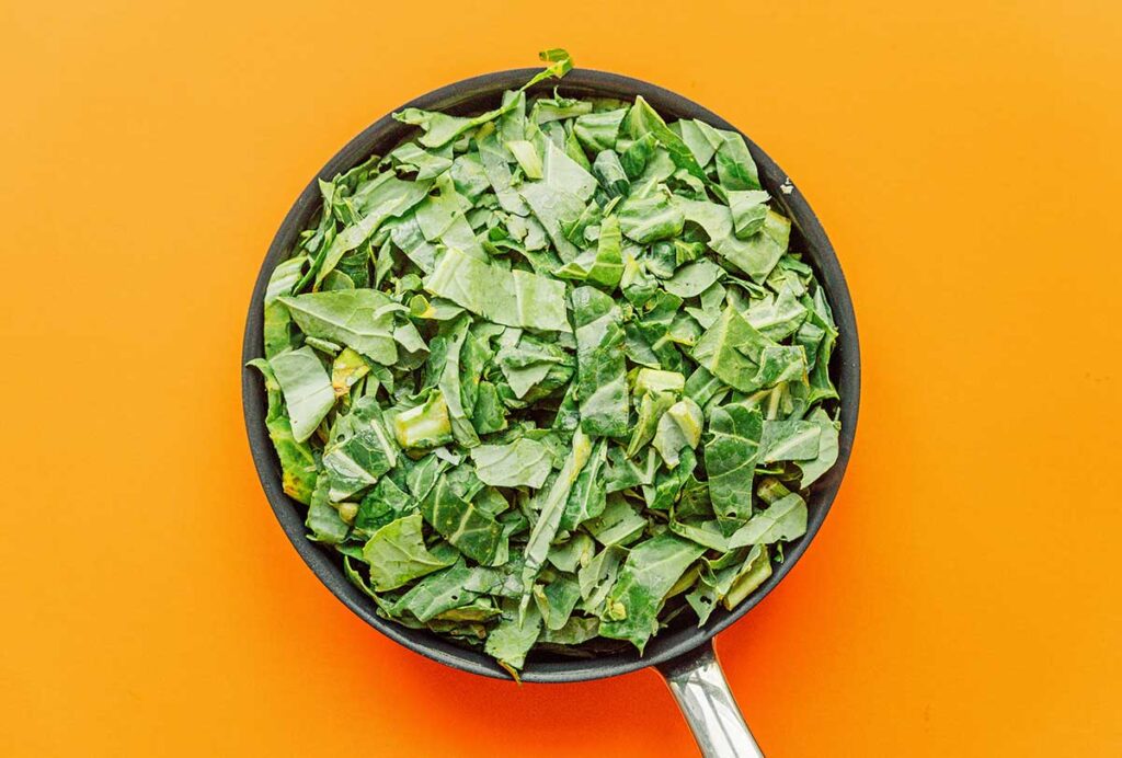 A pan filled with uncooked chopped collard greens