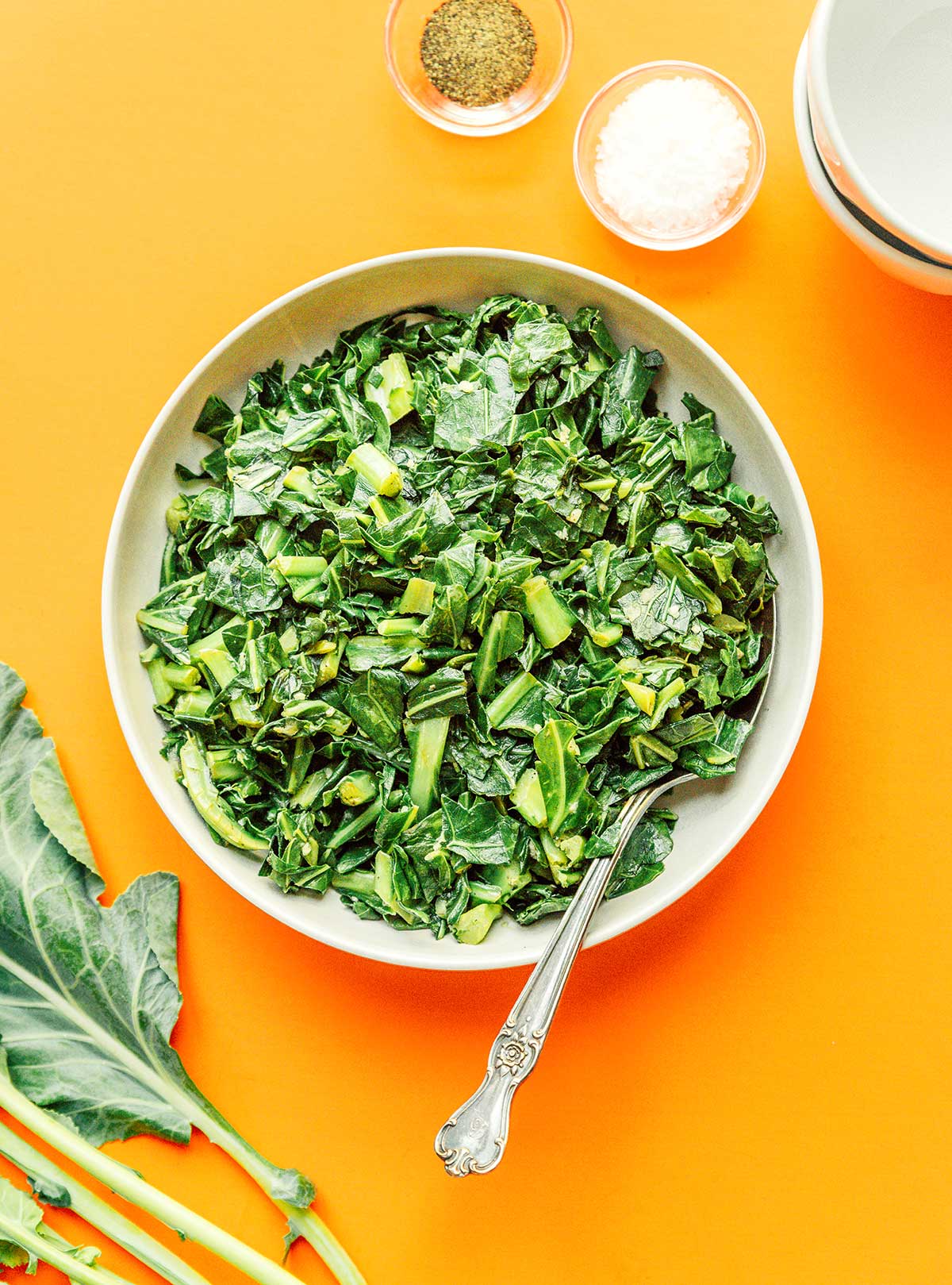 A white bowl filled with freshly sautéed collard greens
