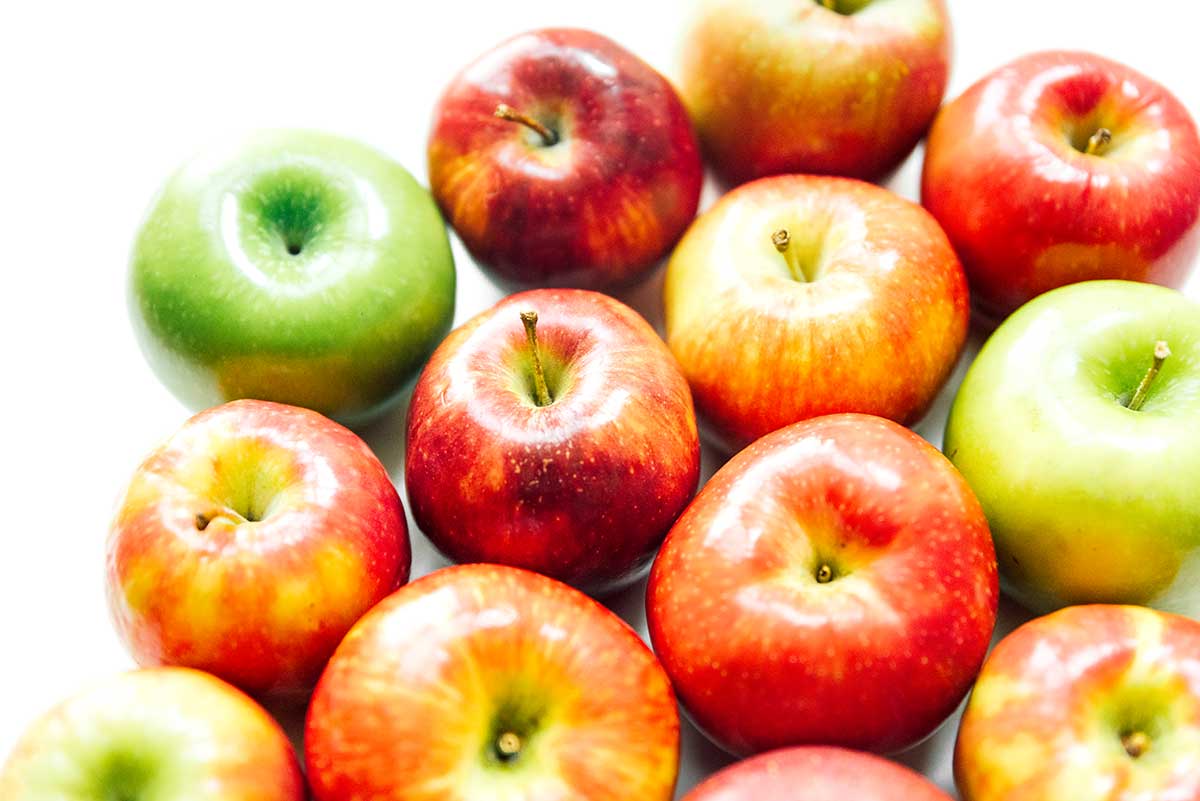 A group of various apple varieties arranged on a white background