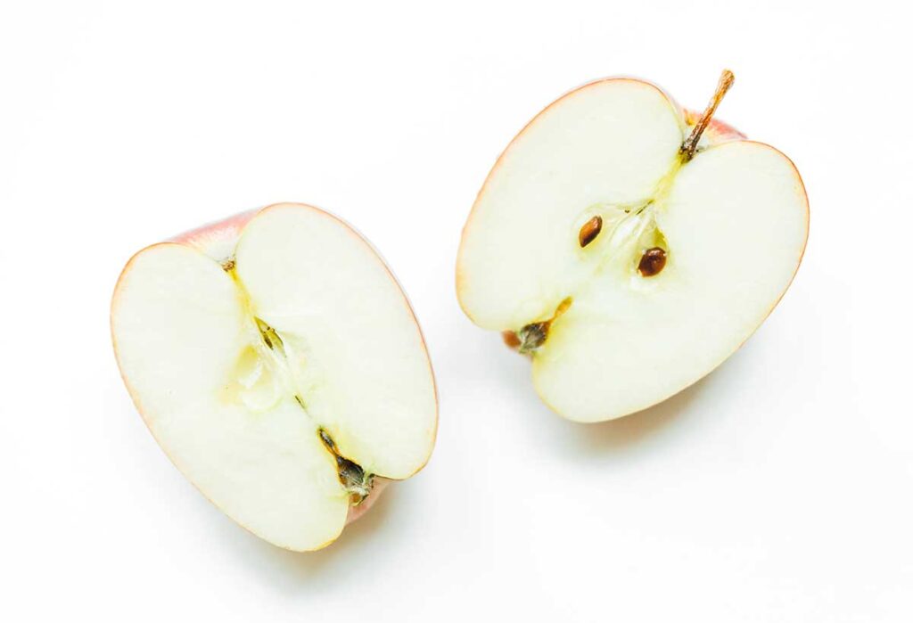 An apple sliced in half on a white background