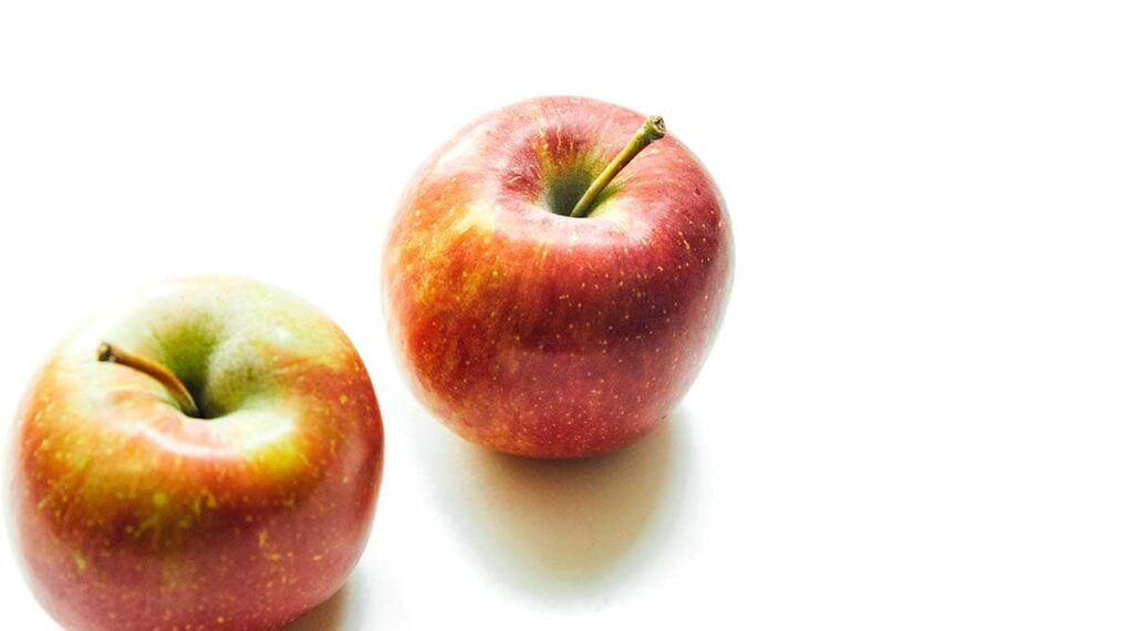 Two fuji apples on a white background