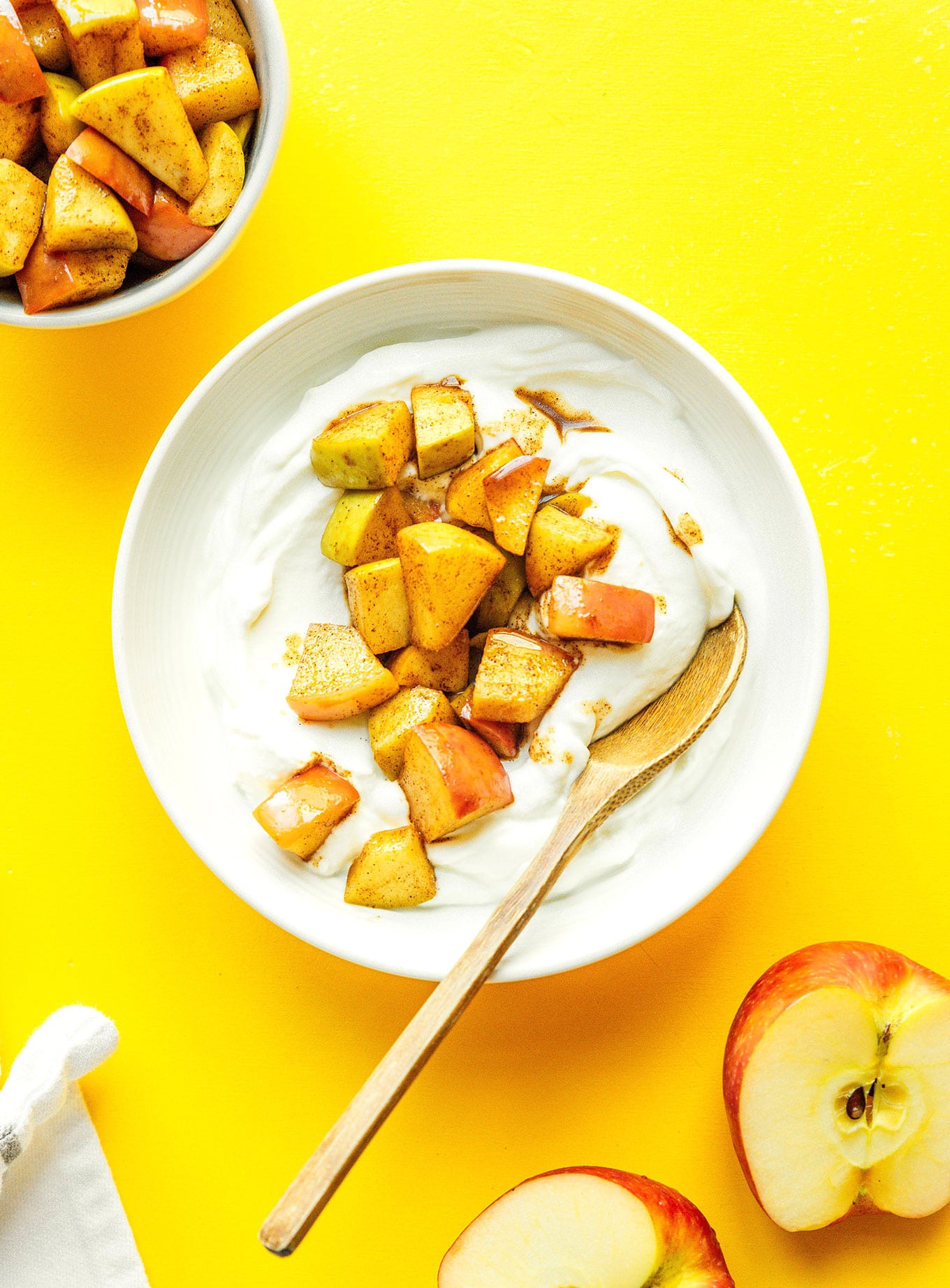 A white bowl filled with yogurt and topped with stewed apples