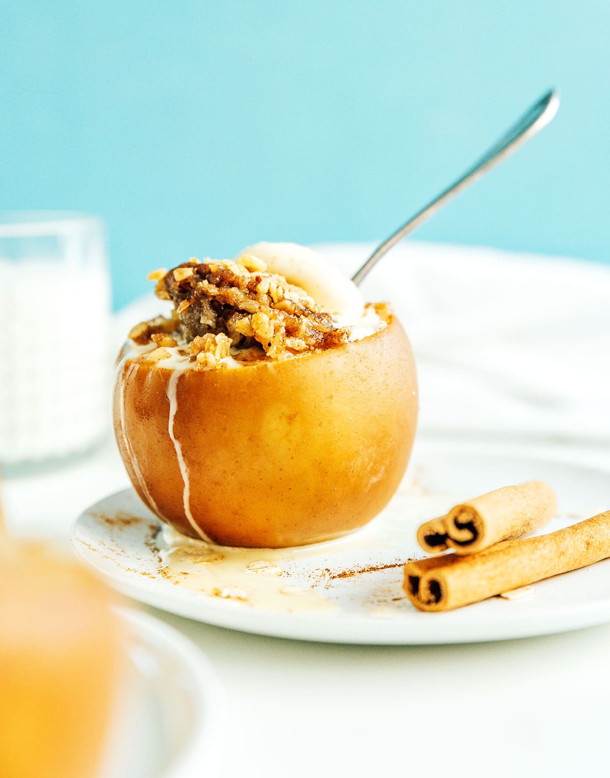 A slow cooker stuffed apple topped with a dollop of ice cream and sprinkled with cinnamon