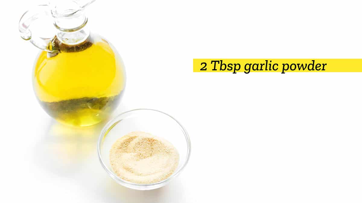 A jar of olive oil and a small glass bowl filled with garlic powder