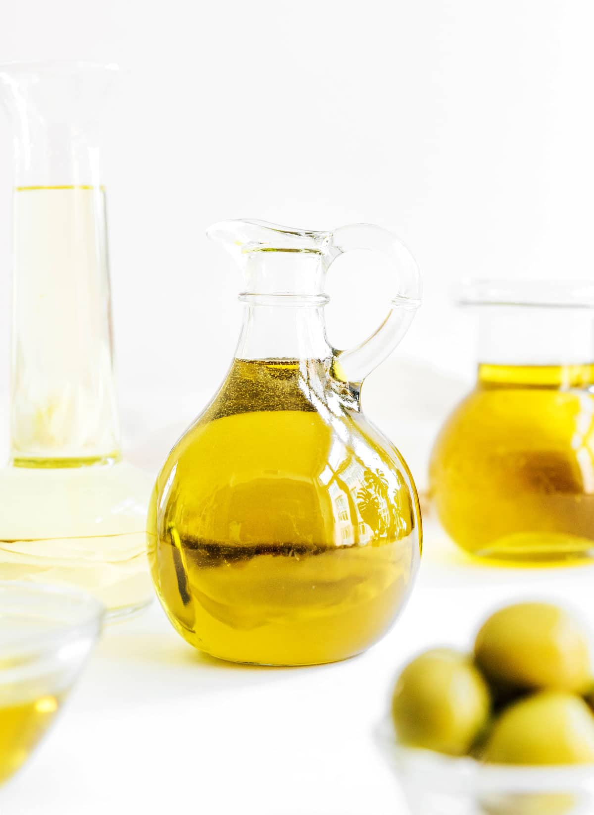 A glass handled jar filled with olive oil