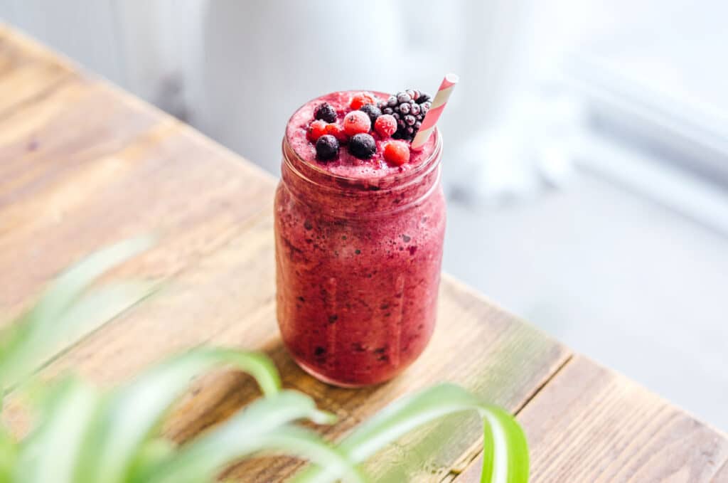 A fresh and icy mixed berry smoothie topped with mixed berries