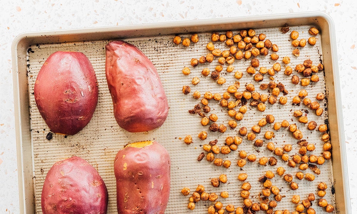 Roasted sweet potatoes and chickpeas on a baking sheet.