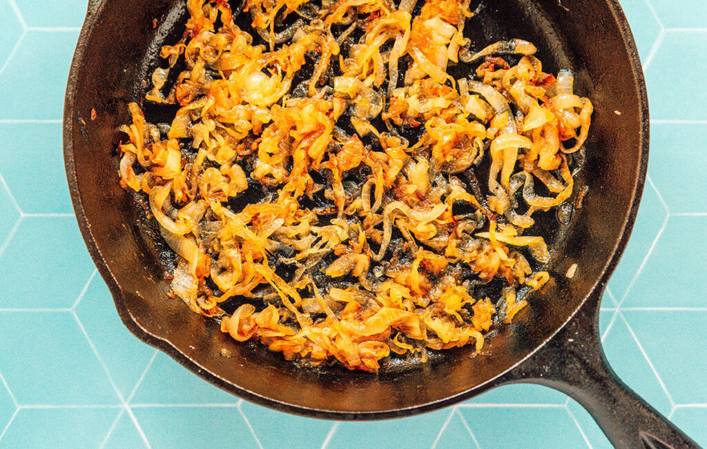 A cast iron skillet filled with caramelized onions