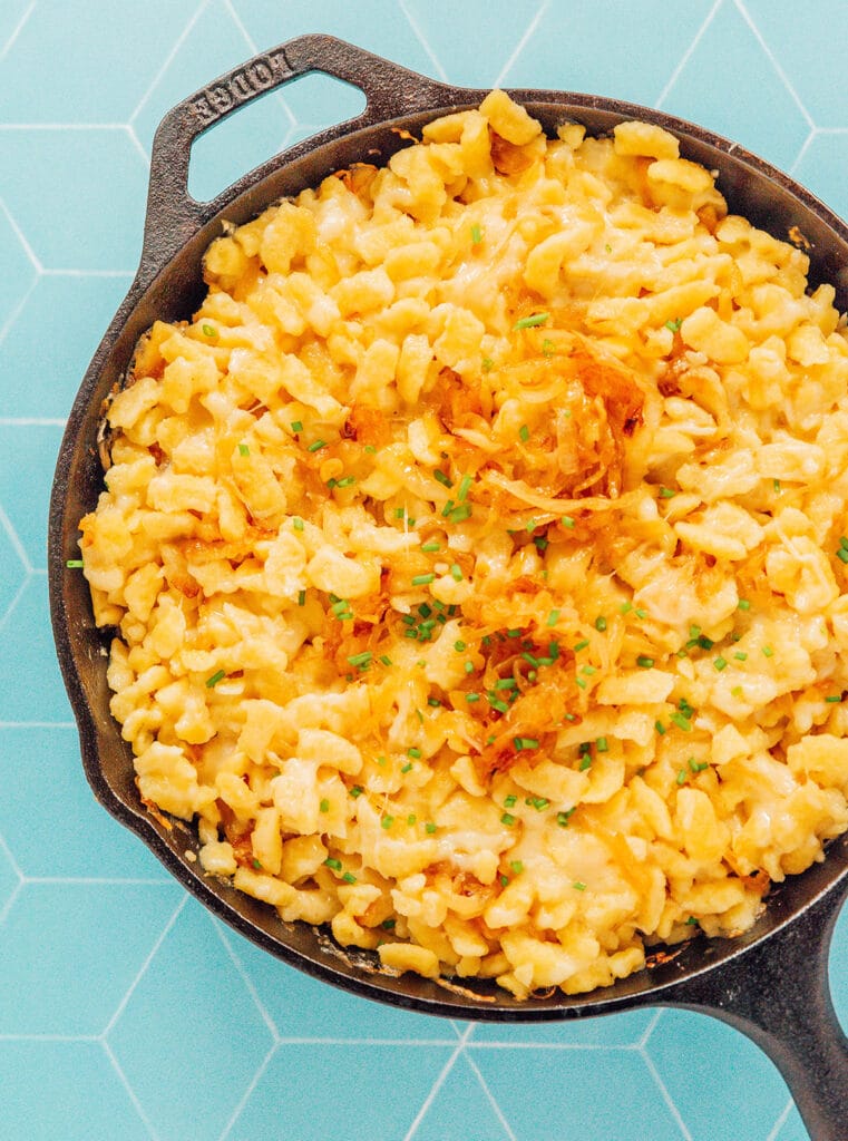 A cast iron skillet filled with fresh out of the oven kaesespaetzle
