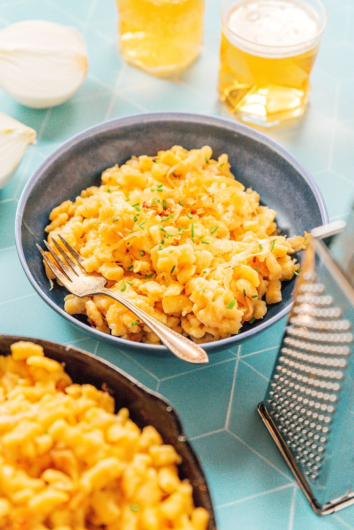 A gray bowl filled with a heaping serving of German Cheese Spaetzle garnished with chives